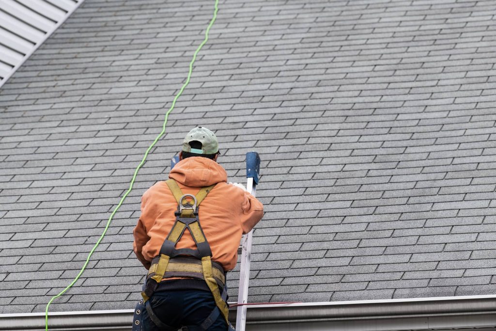 Roof inspector on a ladder.