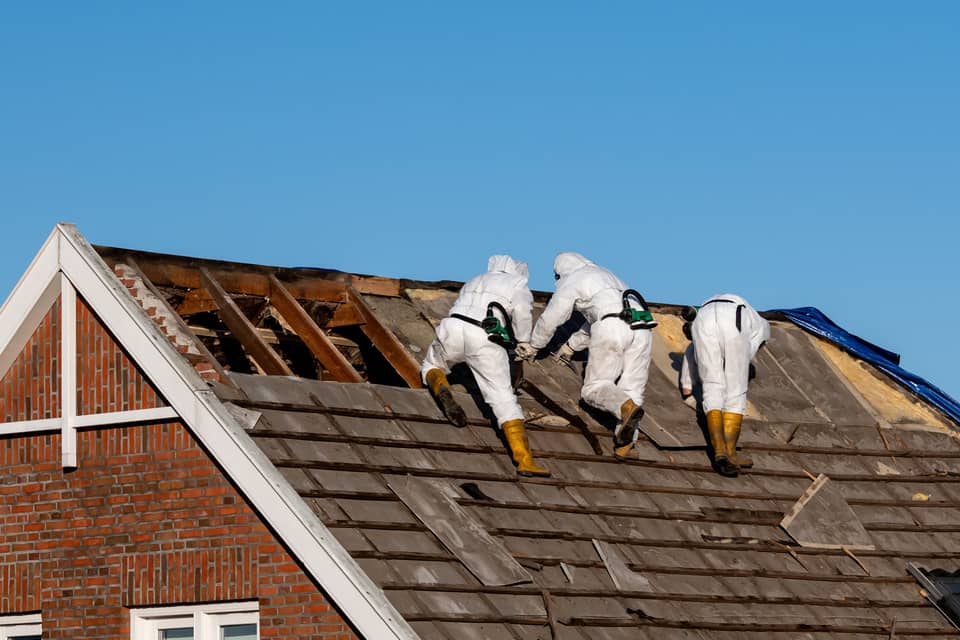 Removal of old asbestos roofing shingles.
