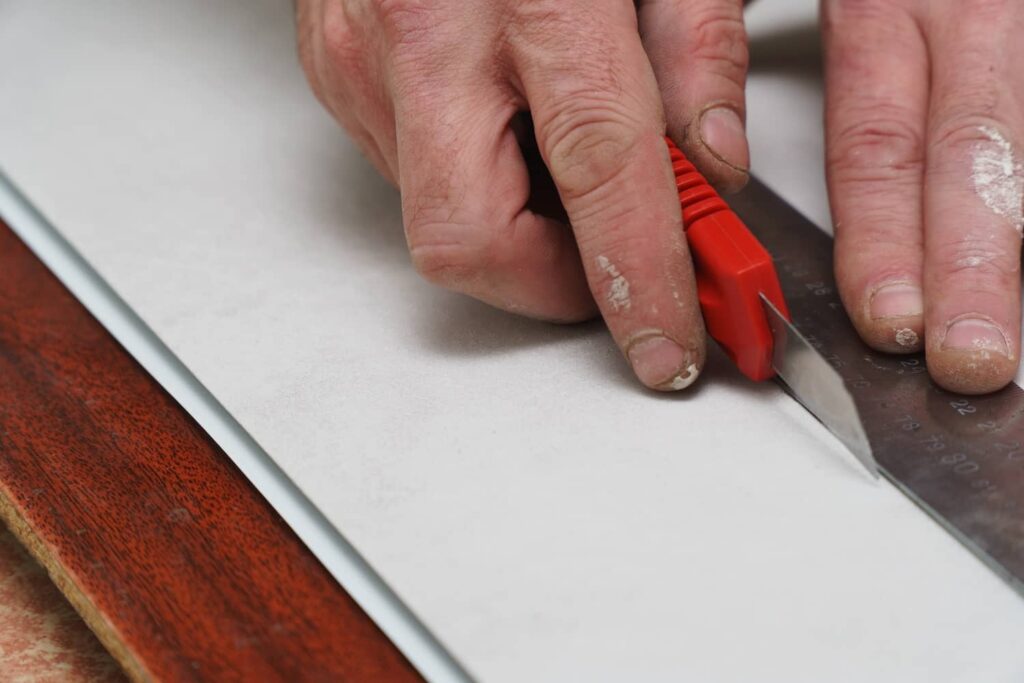 Person making a smooth, straight cut to vinyl siding.