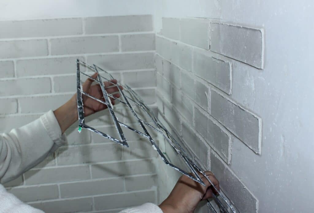 example of a person using a stencil to simulate brick with stucco